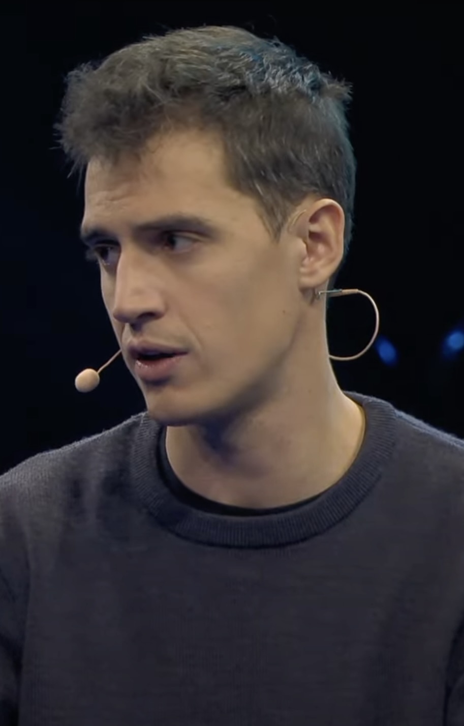 Arthur Mensch, co-founder and CEO of Mistral AI, speaking on stage with a headset microphone