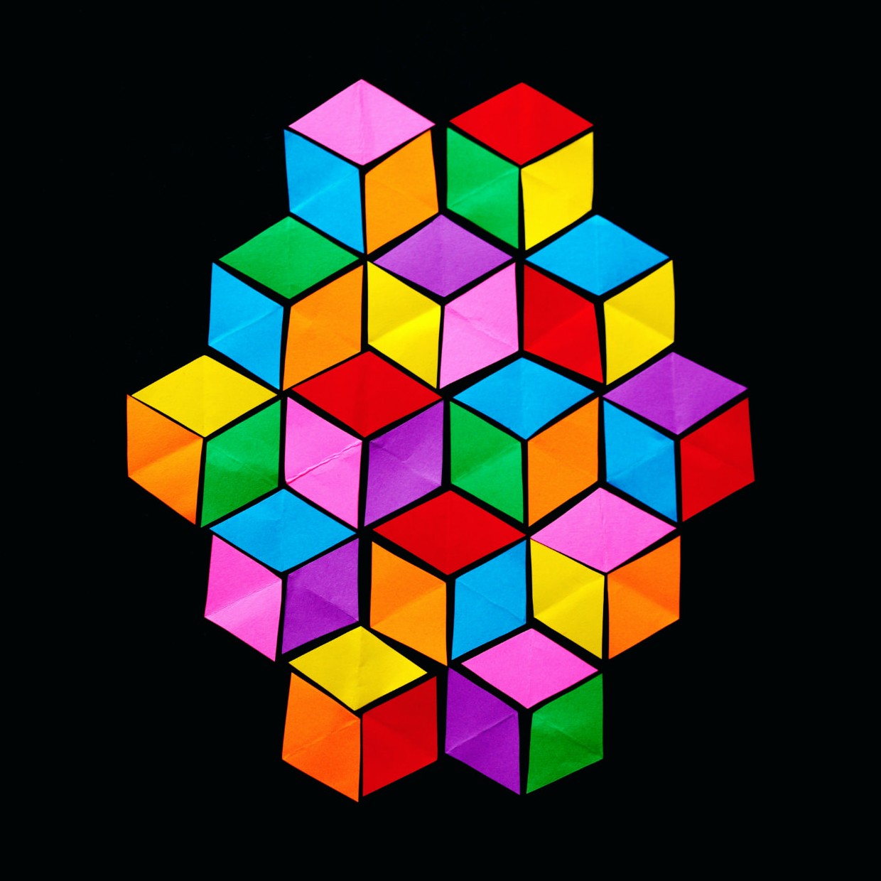A cluster of interlocking isometric paper cubes in bright red, orange, yellow, green, cyan, purple and magenta, each face outlined in black, arranged as a tumbling-blocks optical illusion on a solid black background